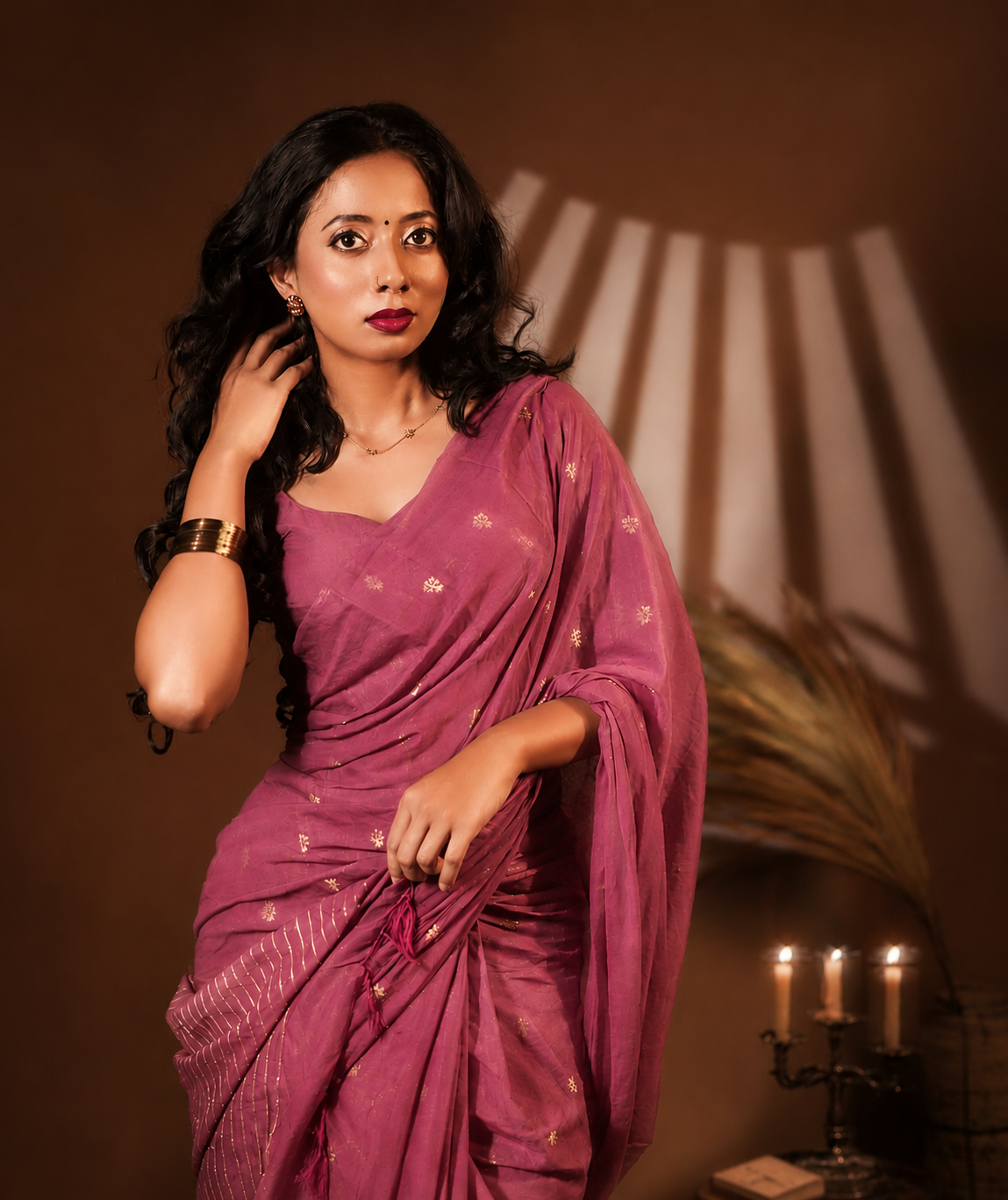 Portrait of a model wearing the rich berry-pink Katan Silk ready-to-wear pocket saree, scattered with tiny golden floral motifs, fine metallic linear lower pleat stripes, and soft tassels.