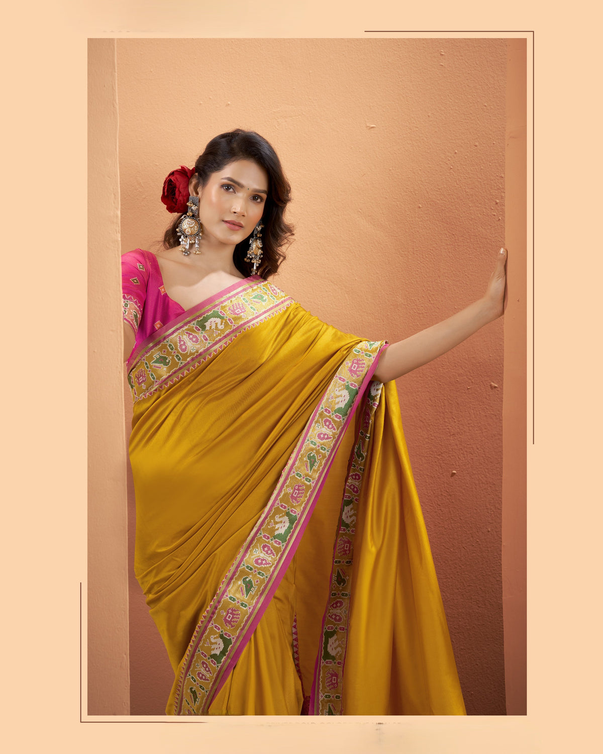 Close-up of mustard yellow Patola Silk saree showing its multicoloured patterned border