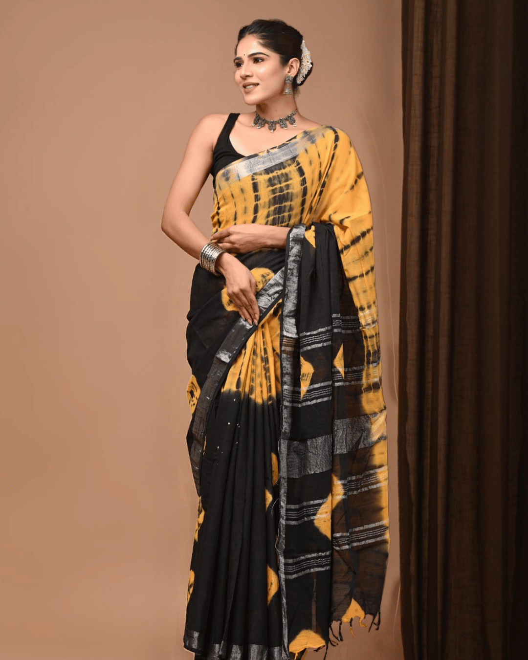 Golden-yellow and black linen ready-to-wear pocket saree with irregular black streaks, broad black panels, silver-grey striped sections, a finely lined pallu and dark tassels.