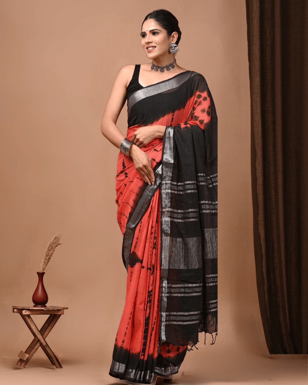 Elara linen ready-to-wear pocket saree in coral red and black with abstract tie-dye patterns, metallic-grey border and striped black pallu.