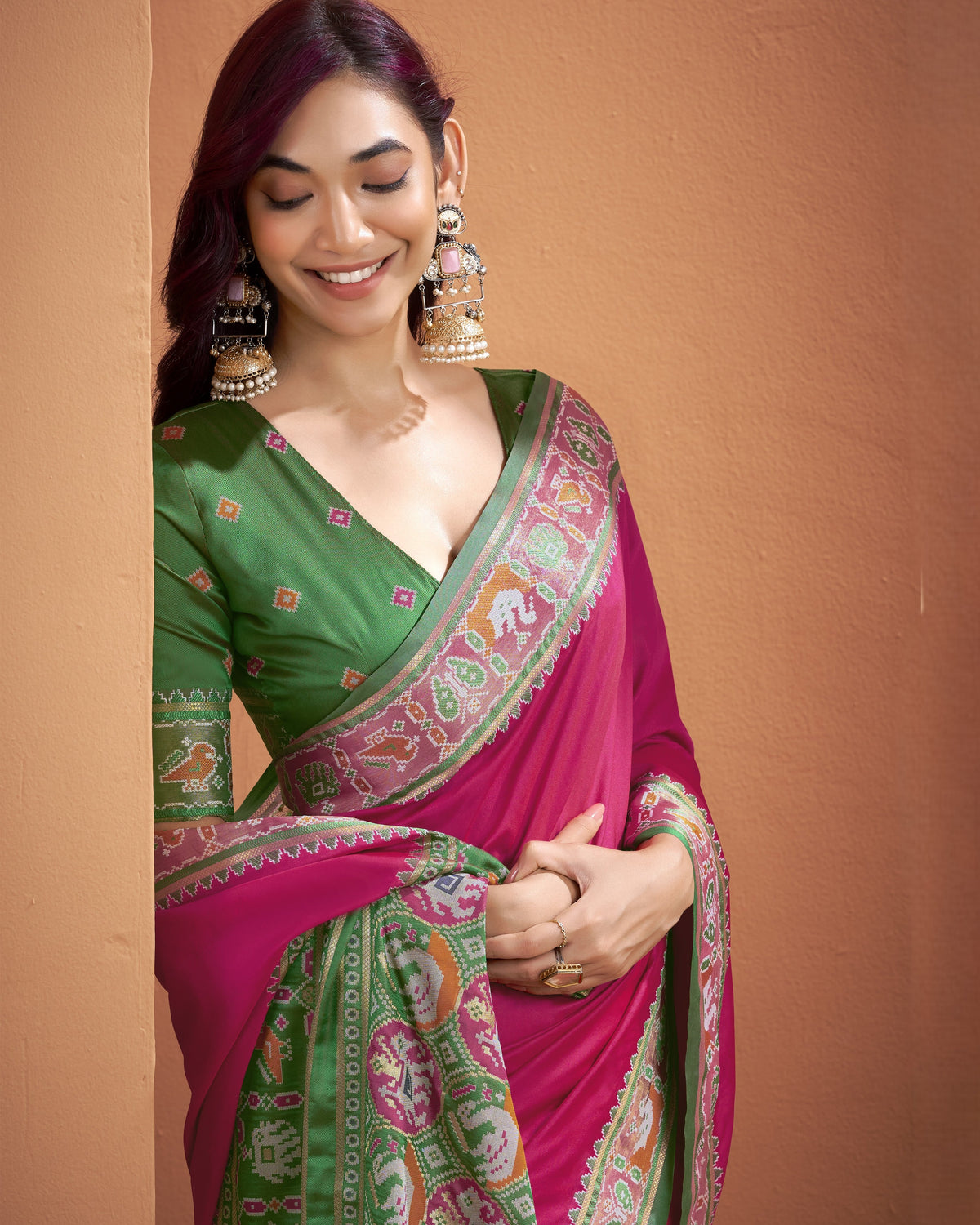 Close-up of pink Patola Silk ready to wear pocket saree showing multicoloured geometric border and motifs