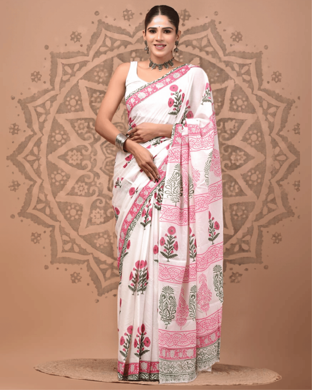 Ivory Mul Cotton ready to wear pocket saree with pink floral sprigs and olive-green leaves, a pink ornamental border, and a pallu featuring alternating pink patterned bands and green botanical panels.