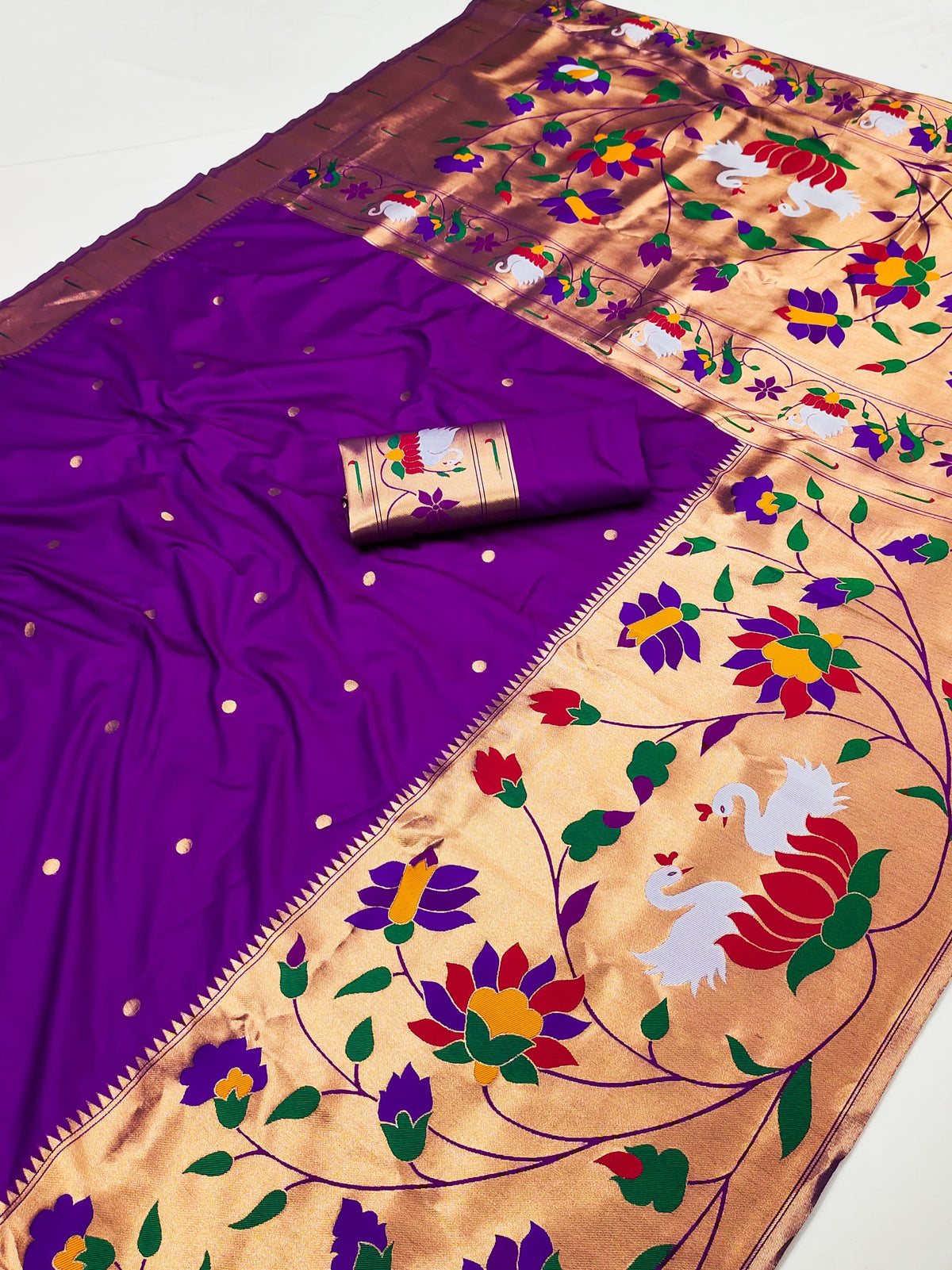 Flat-lay shot of the Utsav Umang purple Paithani silk ready to wear pocket saree, displaying the deep purple fabric with golden butis and ornate gold pallu featuring colourful floral vines and bird motifs.