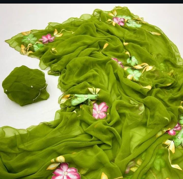 Overhead flat-lay shot displaying the fluid chiffon pre-draped pocket saree in fresh green with pink and lime floral motifs and fine scalloped edges.