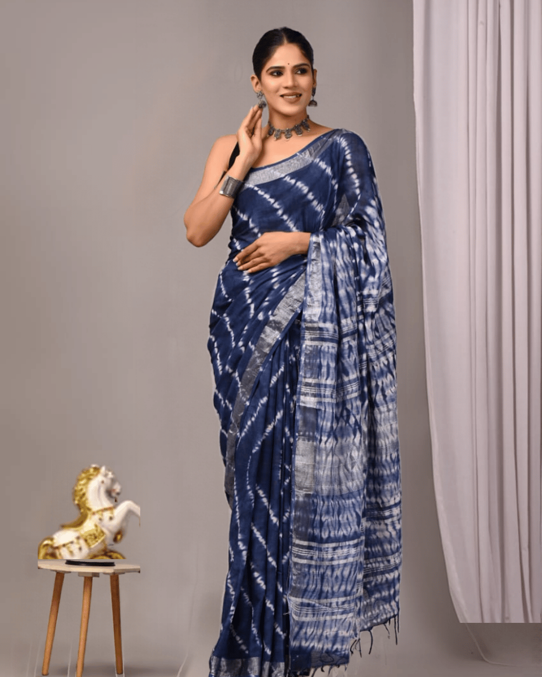 Linen Muse navy-blue linen ready-to-wear pocket saree featuring silver-white diagonal tie-dye patterns, a striped geometric pallu, a silver-toned border and dark navy tassels.