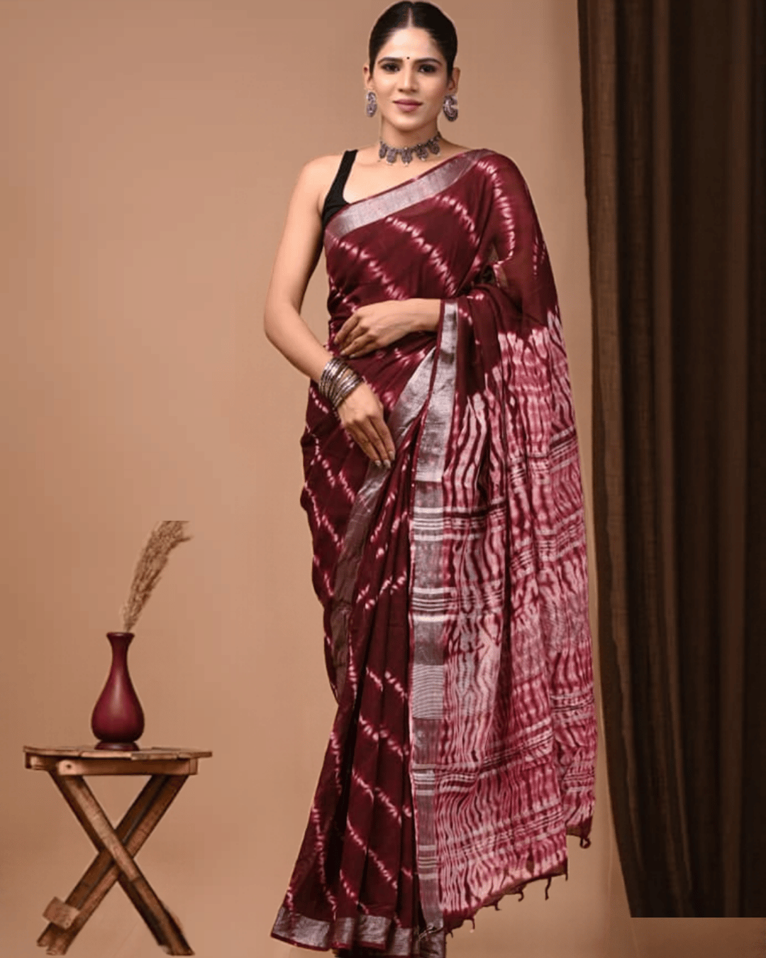 Linen Muse Linen Ready To Wear Saree is a deep wine-red linen saree featuring white diagonal streaks, a silver-grey border, a patterned pallu, and edge tassels.