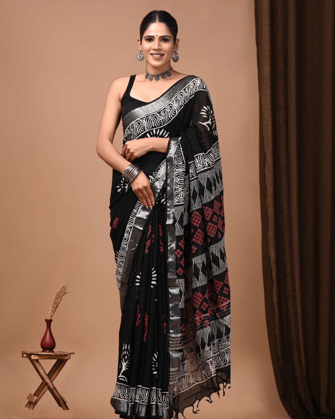 RaatRaaz black linen ready-to-wear pocket saree with white sunburst motifs, red geometric accents, a grey border, wavy white pattern, striped pallu and black tassels.