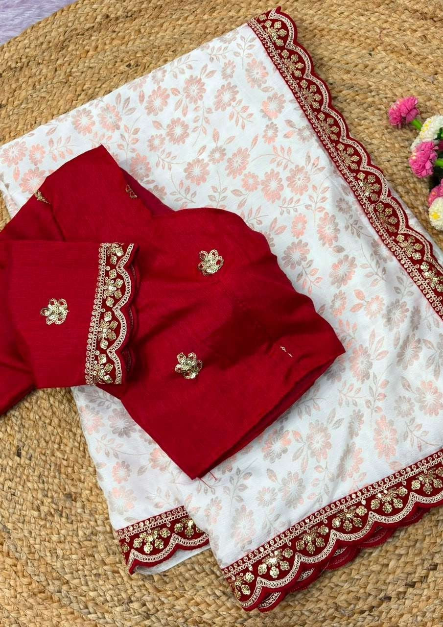 Flat-lay detail shot of the Riwaaz Dola Silk saree showcasing a soft ivory base with delicate peach floral motifs and a rich crimson red scalloped border.