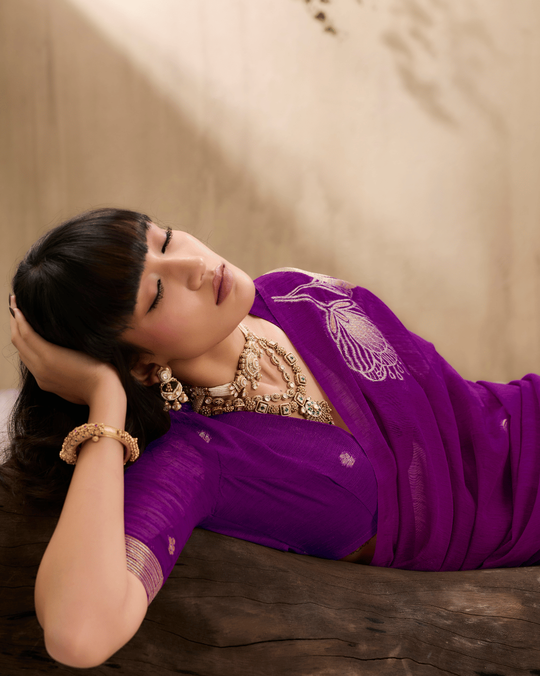 Side profile shot of the model, displaying the rich purple drape with gold floral line art.