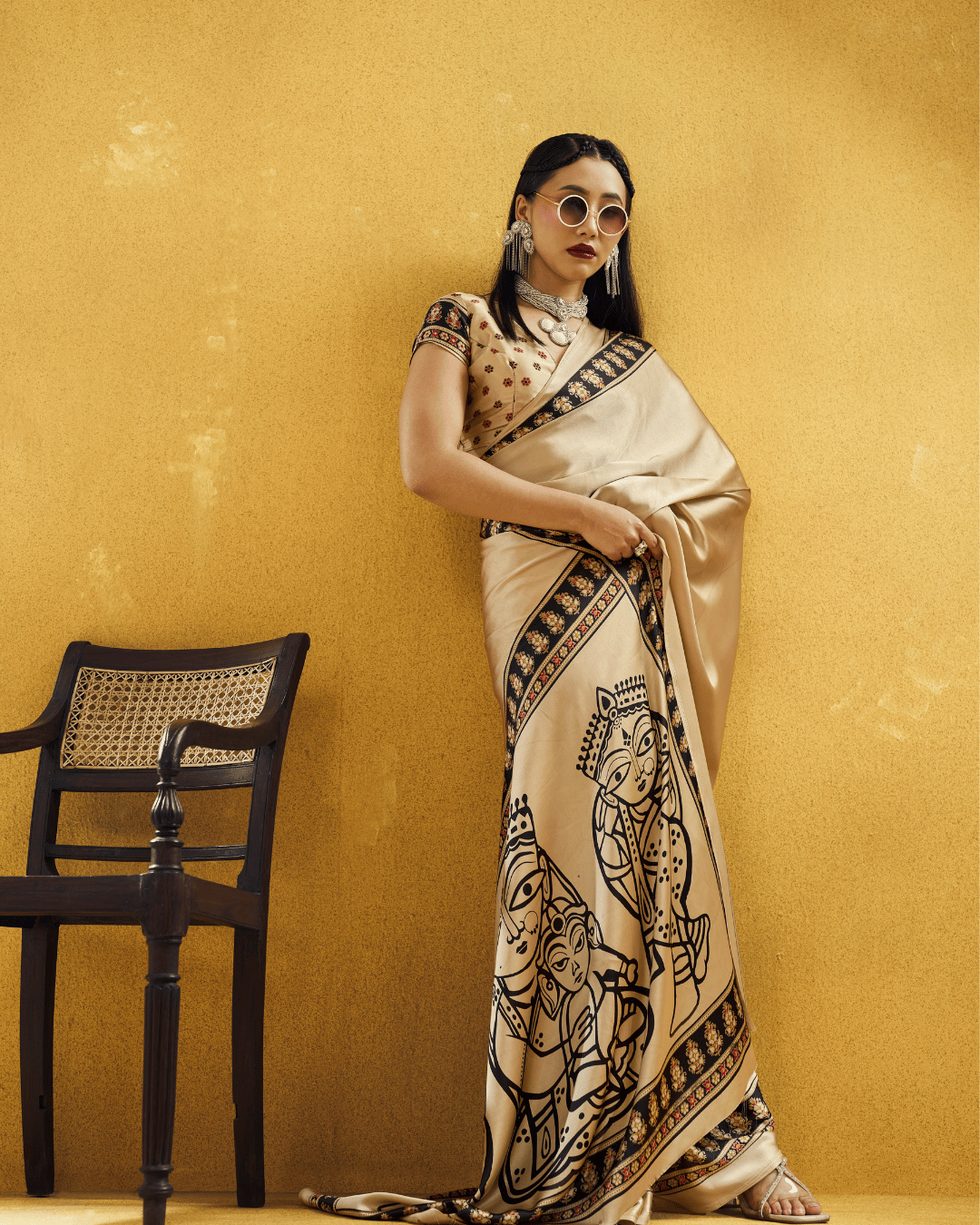 Model standing in the ivory-beige ready-to-wear saree featuring a statement pallu with figurative details.