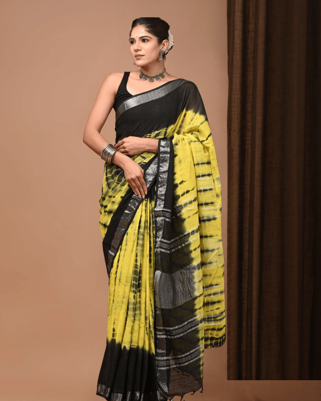 Yellow and black linen ready-to-wear pocket saree with irregular black tie-dye-inspired streaks, a plain black upper section, grey-silver borders, striped black pallu panel and dark tassels.