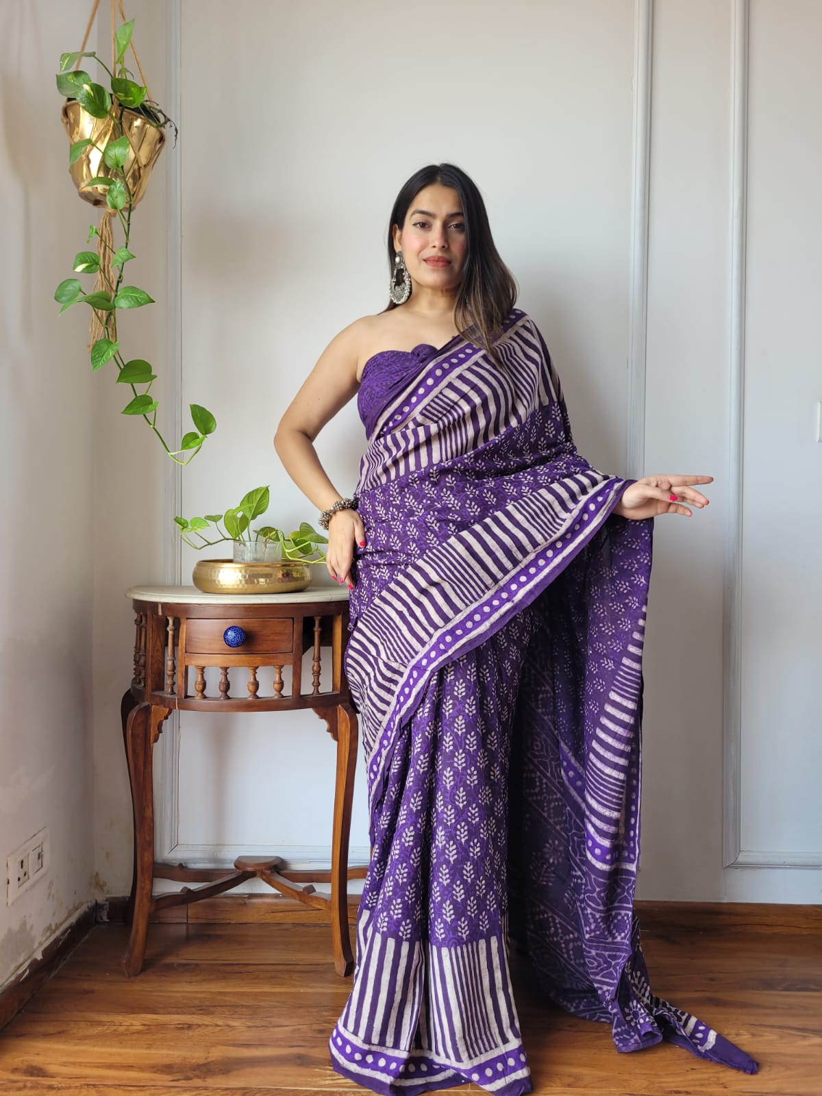 Full-length shot of a model wearing a deep purple Aangan Mul cotton ready to wear pocket saree featuring white block-printed stripes, dotted borders, and floral sprigs.