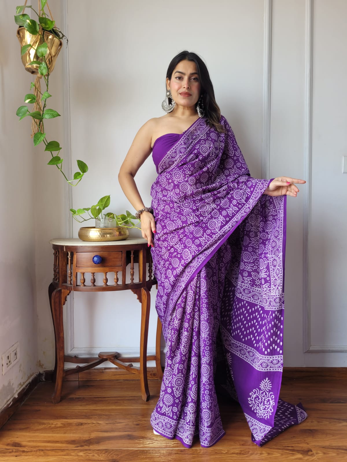 Full-length shot of a model wearing a royal purple Aangan Mul cotton ready to wear pocket saree featuring dense white circular sun motifs, leafy patterns, and a teardrop-accented pallu.