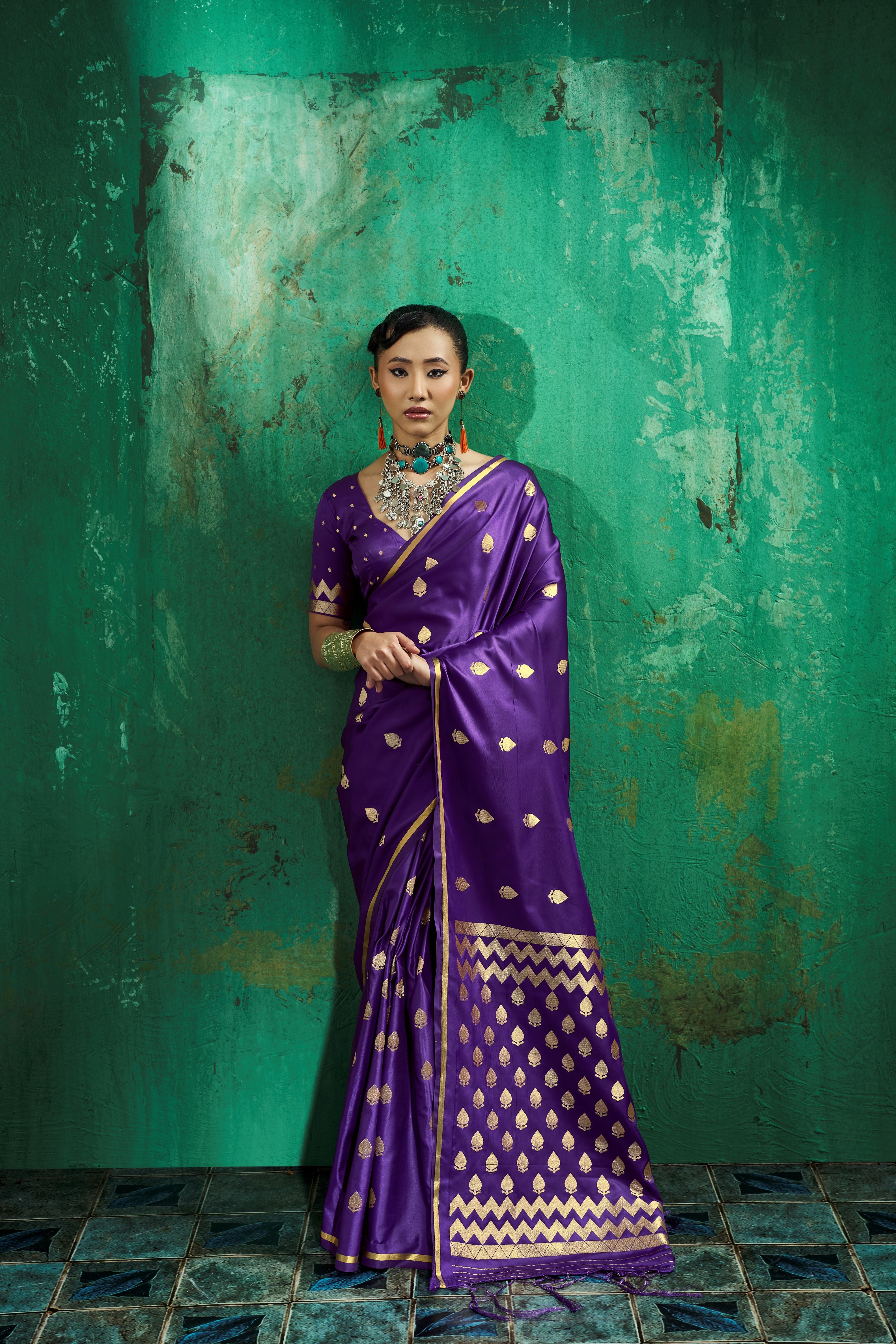Woman wearing an easy drape royal purple satin pocket saree with a woven gold leaf pallu.