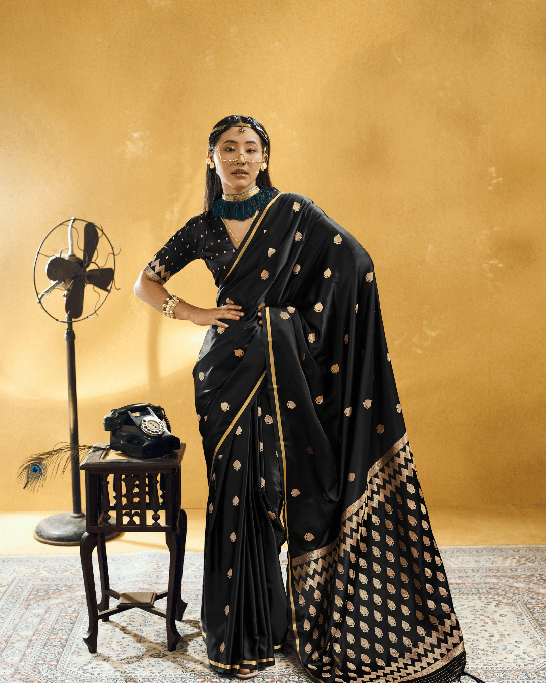 Full-length front-facing shot of the model wearing the Black Chevron ready-to-wear pocket saree, featuring pre-draped front pleats, champagne-gold woven leafy motifs, a metallic gold border piping, and a flowing chevron-patterned pallu.