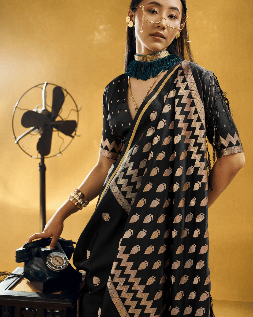 Model in the Black Chevron powerloom silk ready-to-wear pocket saree, showcasing champagne-gold leafy boota motifs and a bold chevron zigzag border.