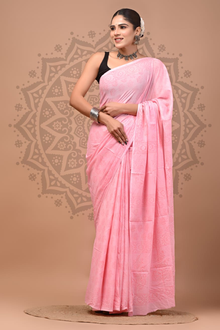 Full-length portrait of a model styled in the Blush Bloom Mul Cotton ready-to-wear pocket saree, featuring a soft pastel pink base, subtle tone-on-tone printed floral panels, pre-stitched pleats, and a delicate pallu.