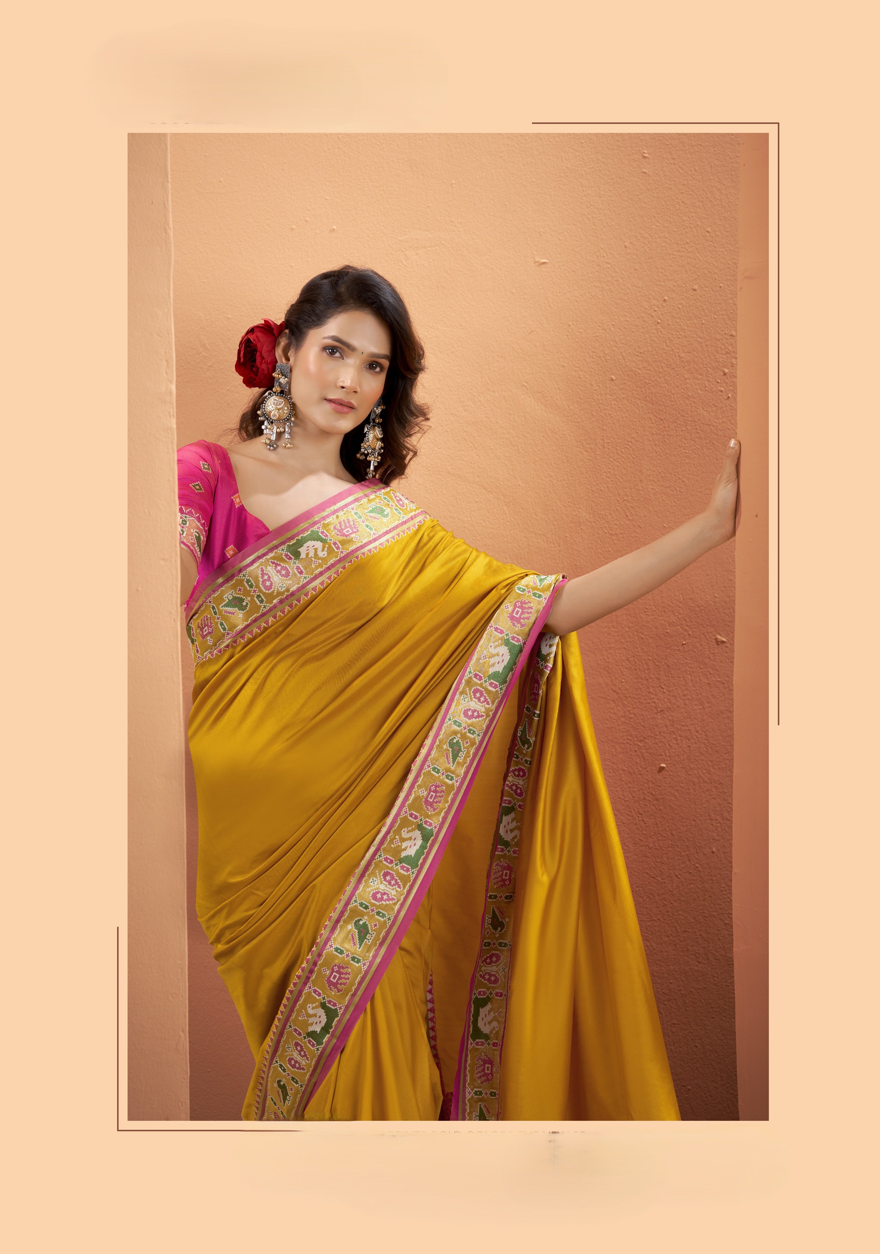 Close-up of mustard yellow Patola Silk saree showing its multicoloured patterned border