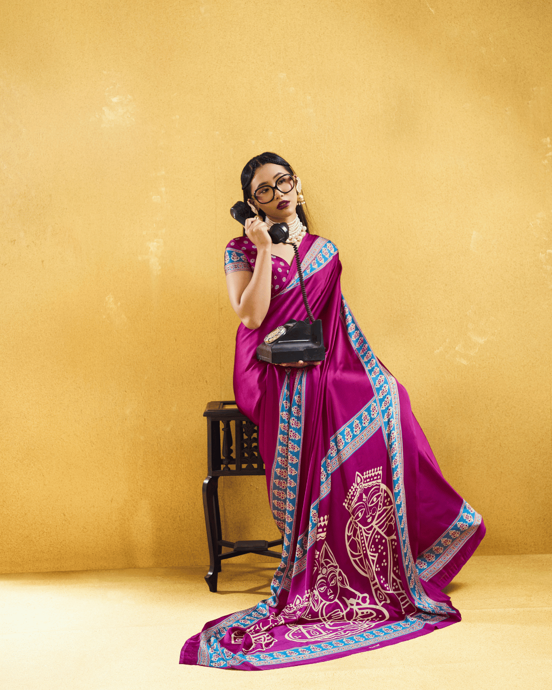 A rich magenta pre-draped pocket saree with a statement pallu featuring folk art motifs.