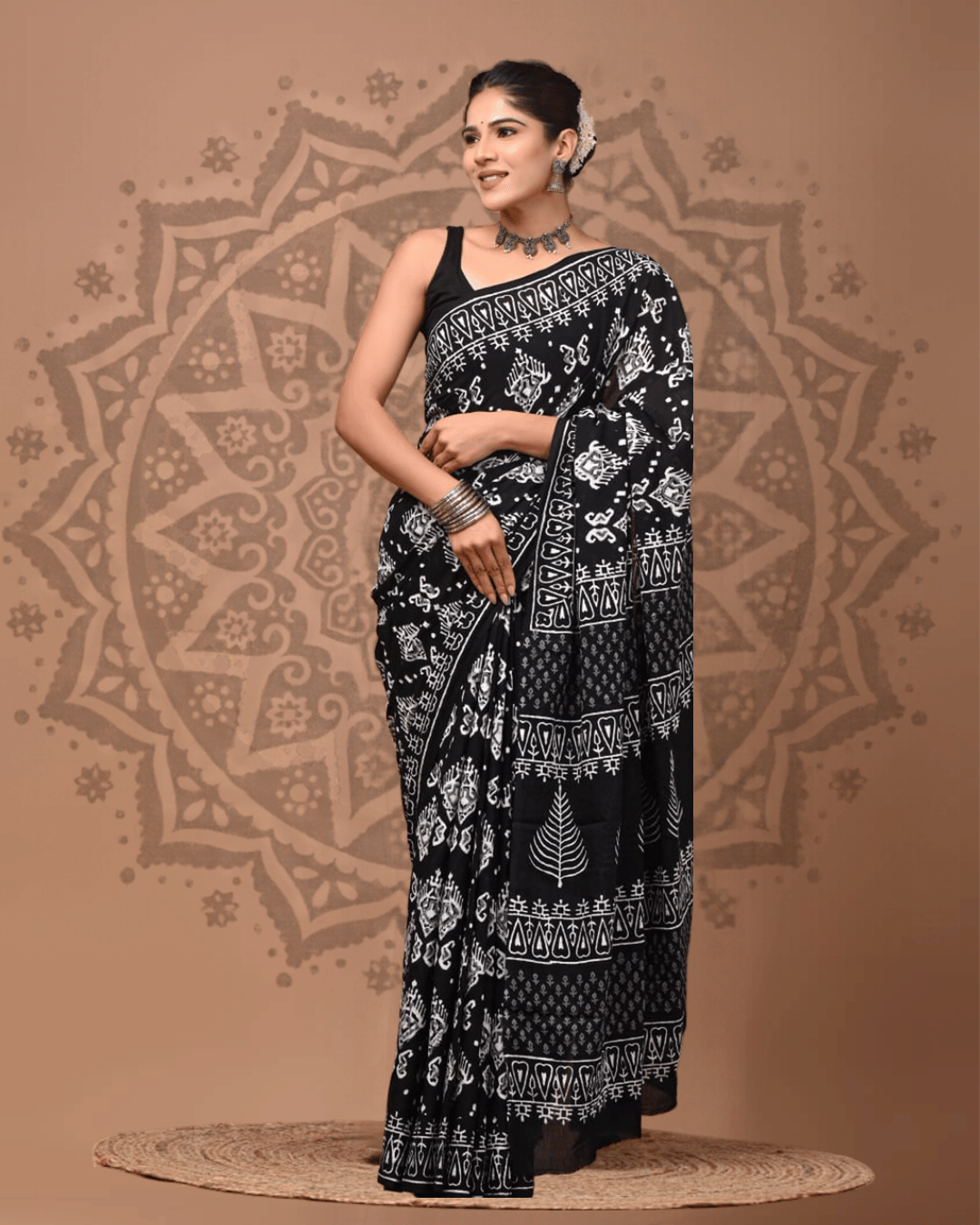 Black Mul Cotton ready-to-wear pocket saree with white folk motifs, geometric borders and a tree-patterned pallu, modelled for a festive look.