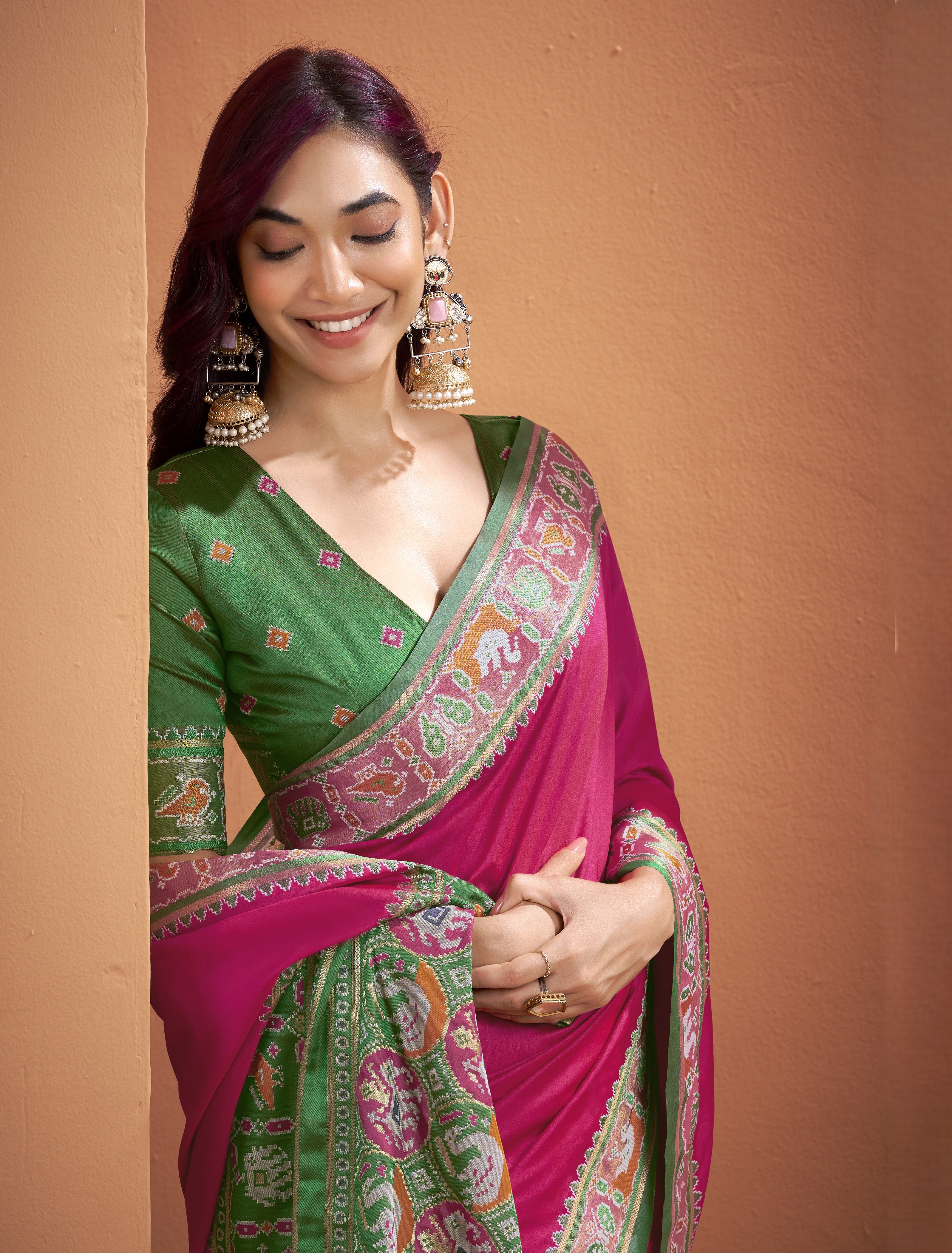 Close-up of pink Patola Silk ready to wear pocket saree showing multicoloured geometric border and motifs