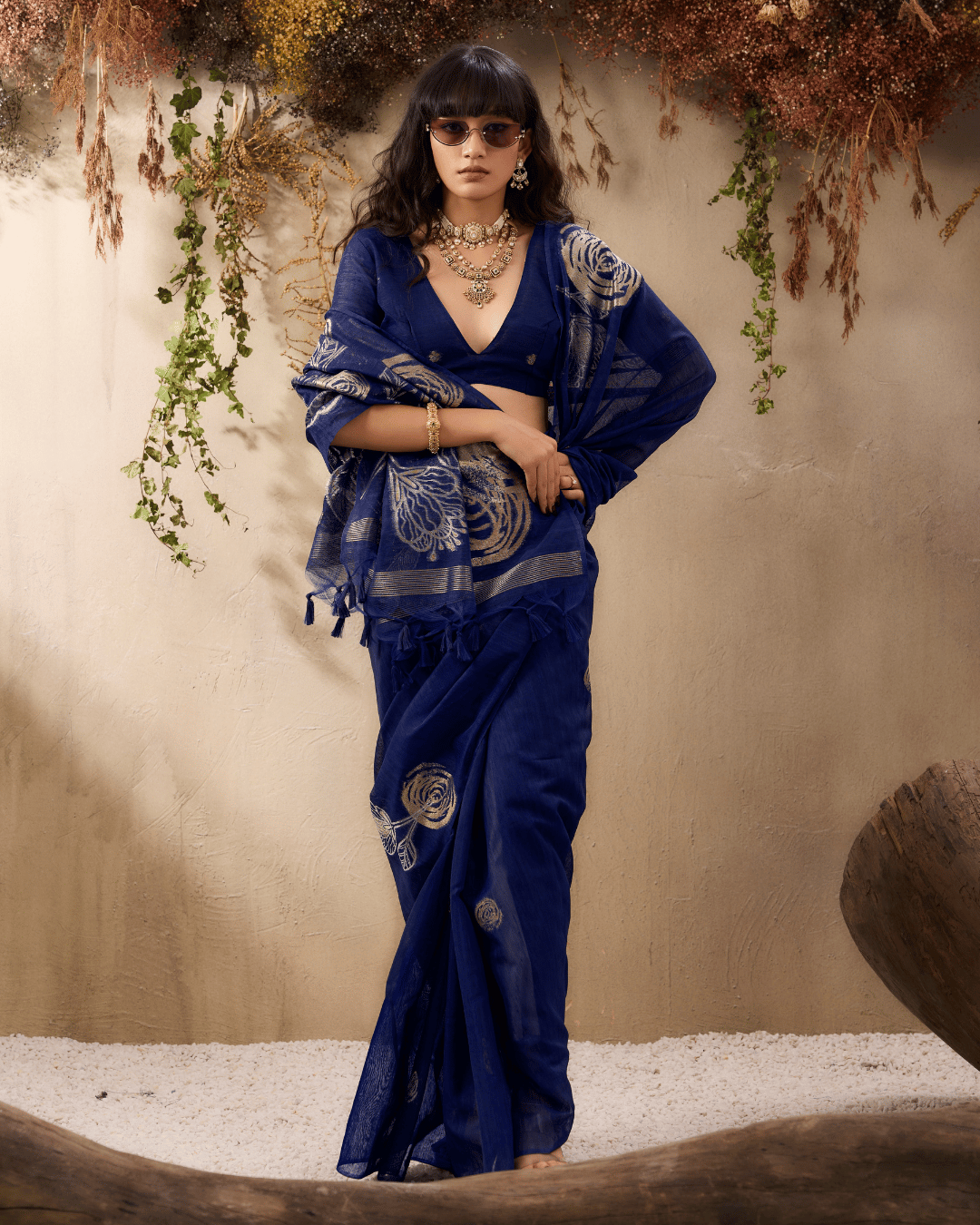 Model showing the sheer navy pallu to showcase the detailed gold rose motifs and fringed tassel ends.