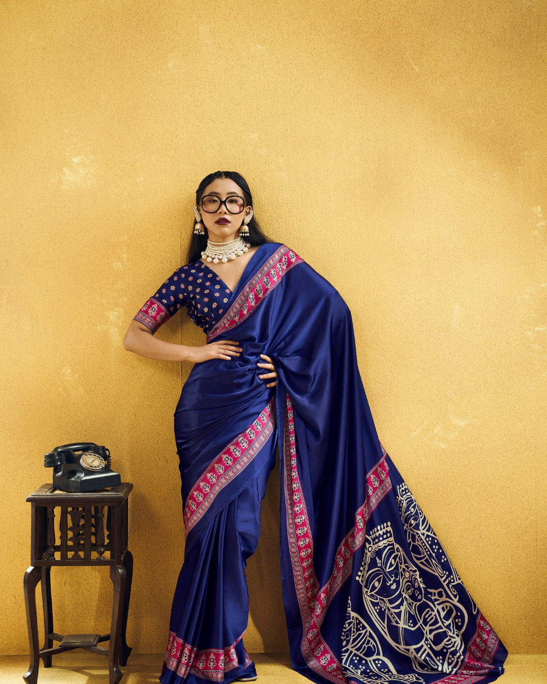 Model posing in a navy ready-to-wear saree, highlighting the contrasting magenta border.