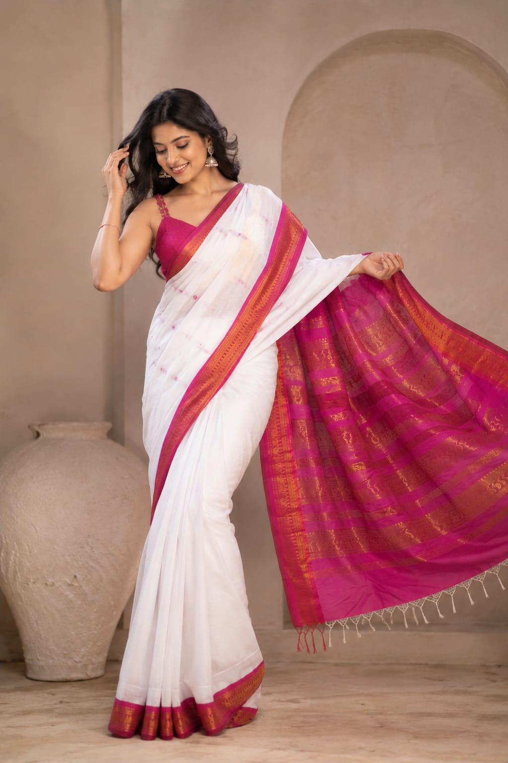 Full-length shot of a model wearing the Gulabi Noor white Cotton ready-to-wear pocket saree, featuring delicate pink accents, a deep magenta border with gold linear detailing, and a rich magenta pallu with traditional gold patterns and tassels.