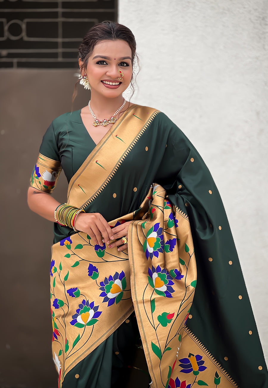 Front shot of a deep green pre-stitched Paithani saree with an antique gold-toned pallu decorated with colorful flowers and bird motifs.