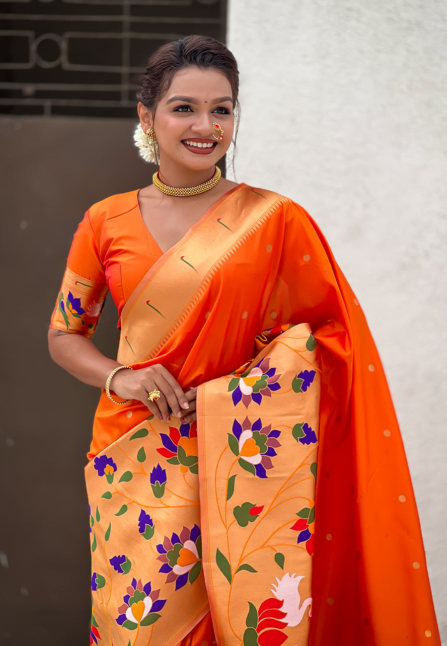 Front shot of a bright orange ready-to-wear Paithani saree with an elaborate floral and swan-motif pallu.