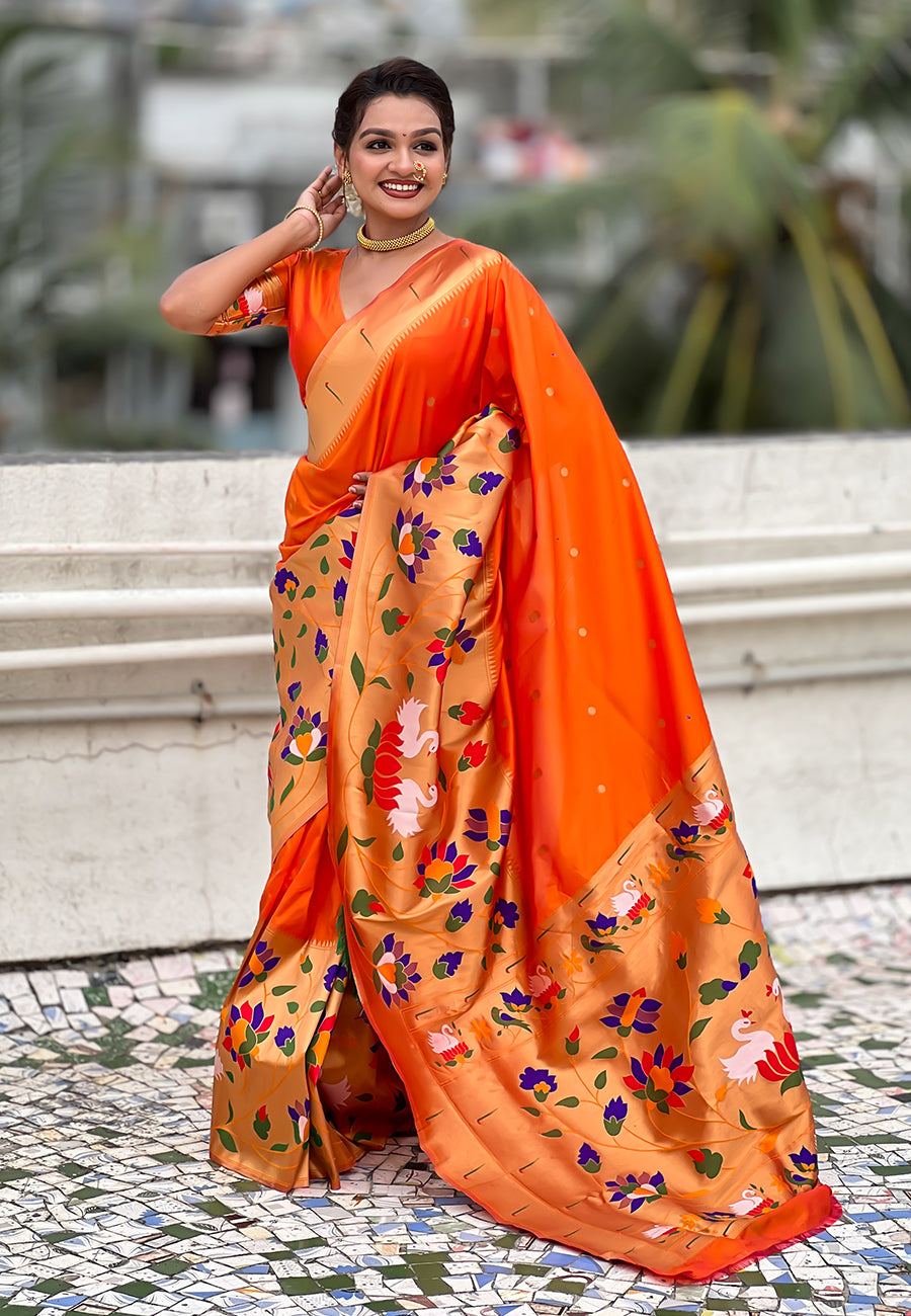 Full-length shot of a vibrant orange pre-draped Paithani saree with a richly detailed contrast pallu and pre-arranged pleats.