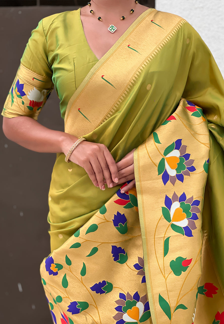 Mid-shot detail of a mehendi green pre-stitched saree showing the structured drape and colorful floral-and-bird design pallu.
