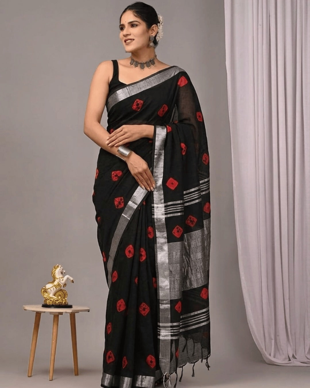 Model wearing the Rangrekha black linen Ready to wear pocket saree with red motifs, silver borders, and a patterned pallu.