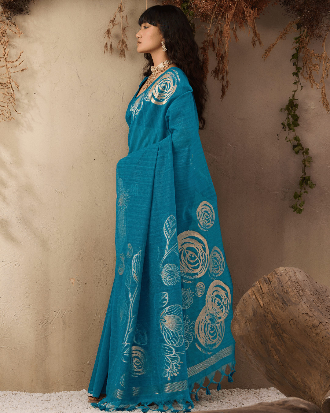 Side shot of the pre-draped pocket saree showing the fluid drape, neat pre-set front pleats, and large gold botanical sketch artwork on the lower pallu.