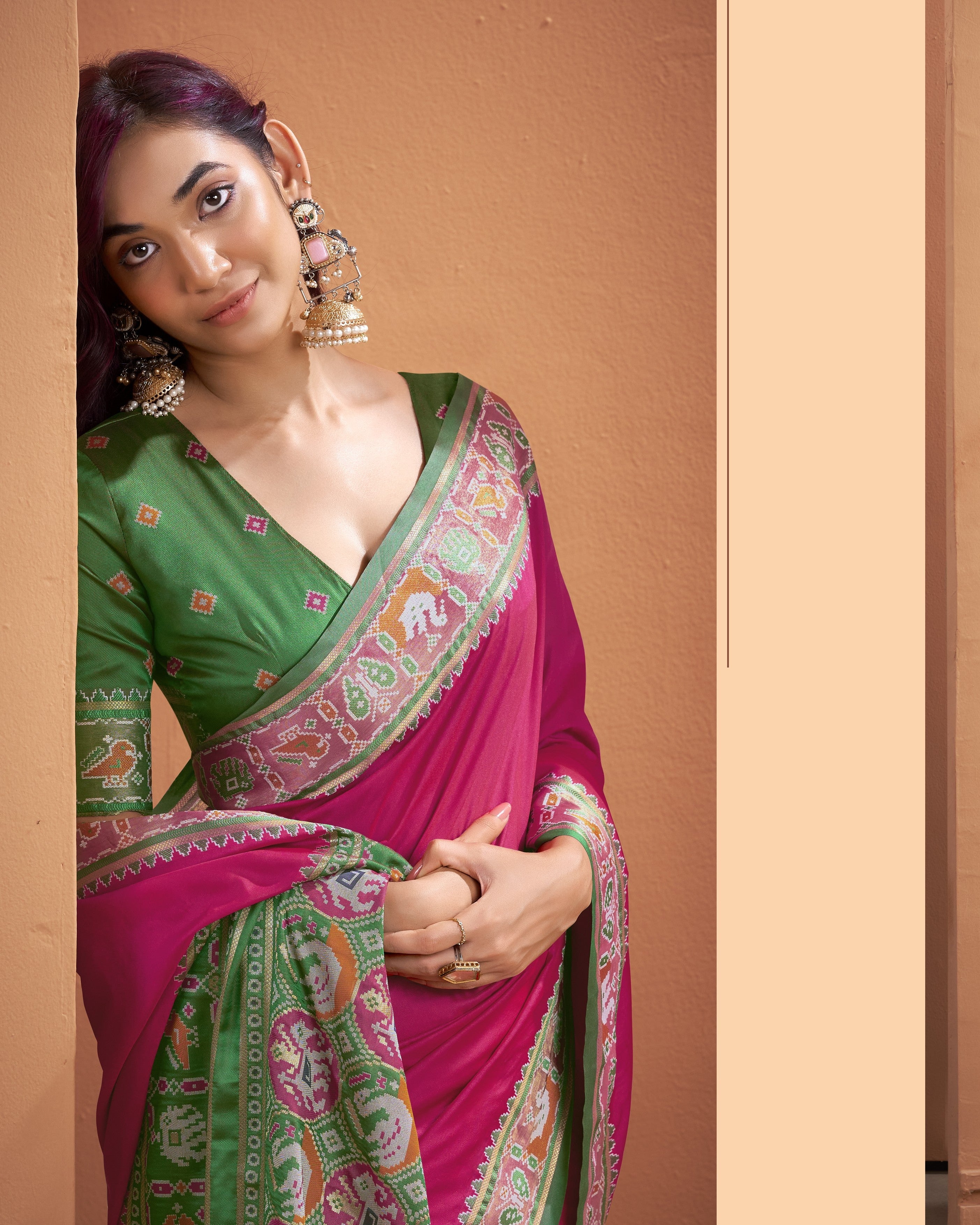 Close-up of Patola Silk ready to wear pocket saree pallu with pink, green, cream, and orange geometric patterns
