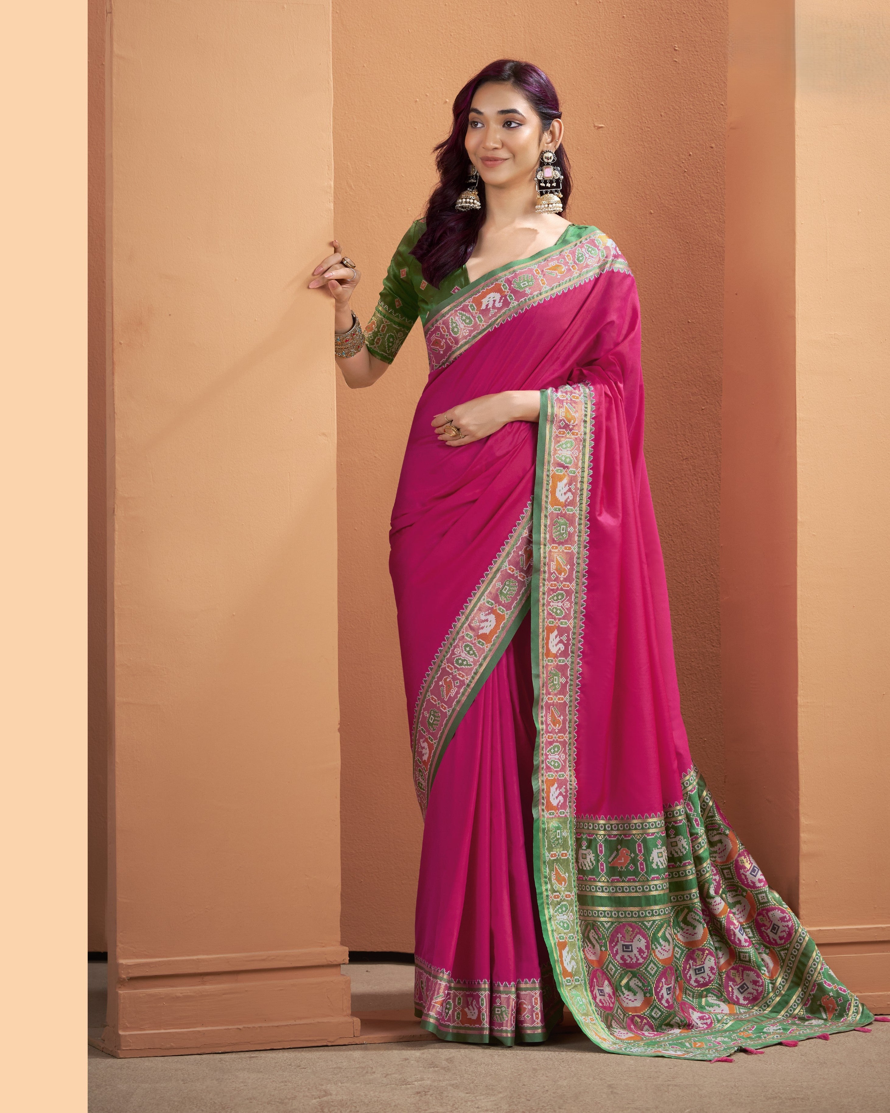 Magenta pink ready to wear pocket saree with detailed green pallu featuring geometric patterns and tassels
